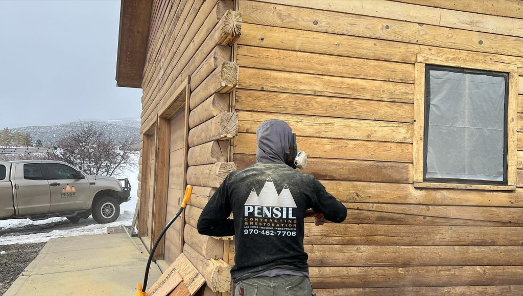 Comparison of media blasting vs. sanding in log home restoration, showing surface preparation methods for refinishing log cabins.